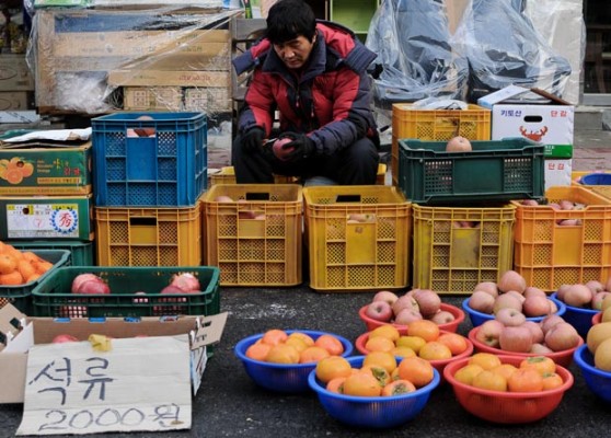 A vendor sells fresh fruit at Sejong City Traditional Market in Jochiwon, South Korea, on Saturday December 14th. The Sejong City Traditional Market has special market days during the month on days ending in 4 or 9. (Salgu Wissmath/ The Sejong Dish)